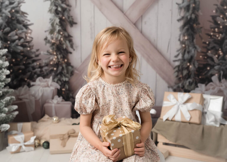 Adelaide child girl with christmas present looking happy. for christmas mini sessions
