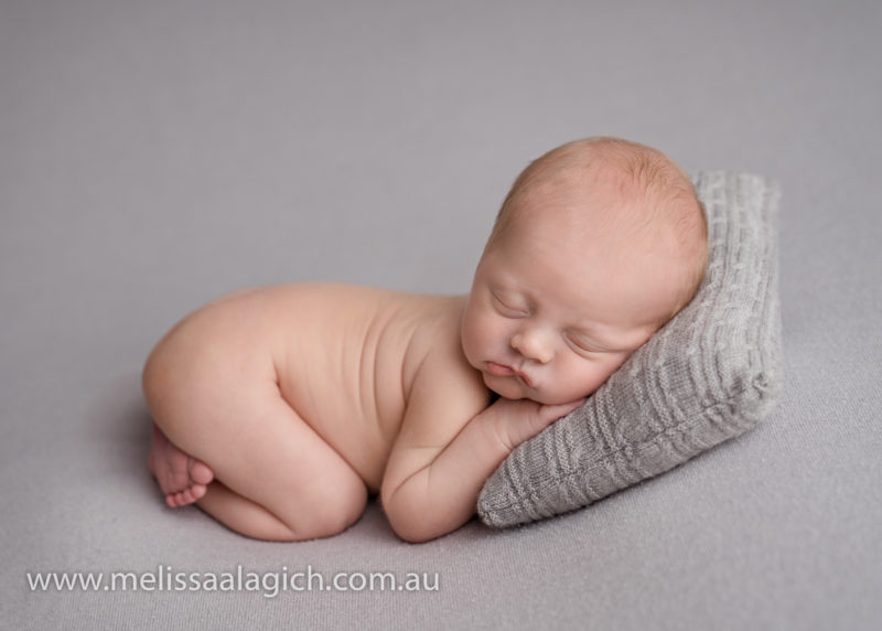 cute baby boy simple newborn photography pose grey pillow